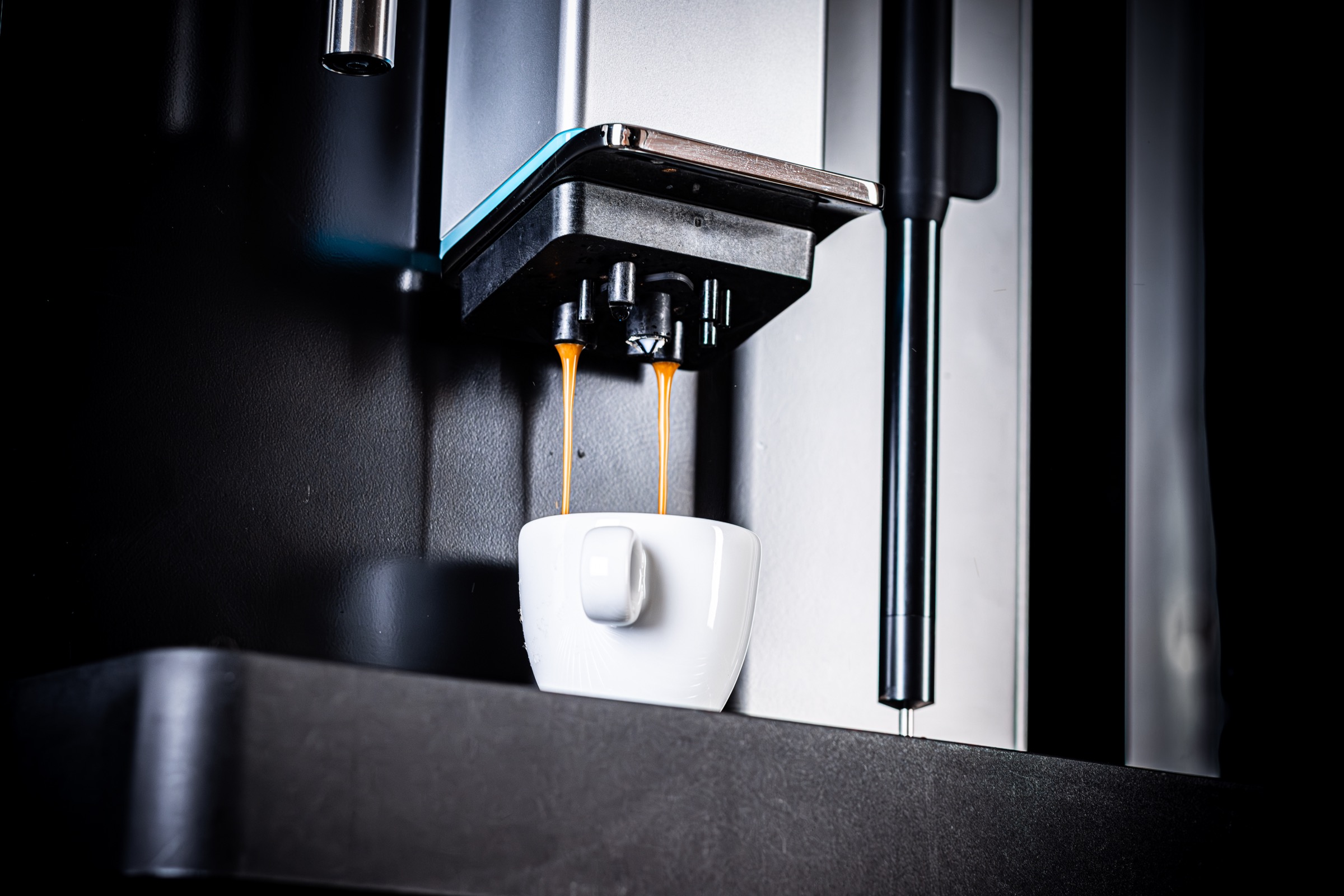 Verse espresso stroomt uit een volautomaat in een witte kop